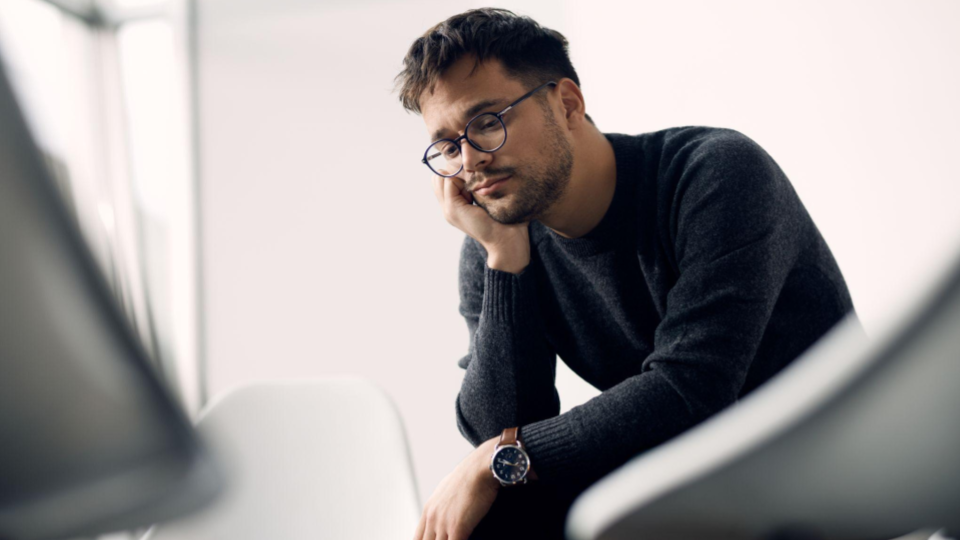 Esta imagem retrata um homem jovem em um momento de profunda reflexão ou cansaço.