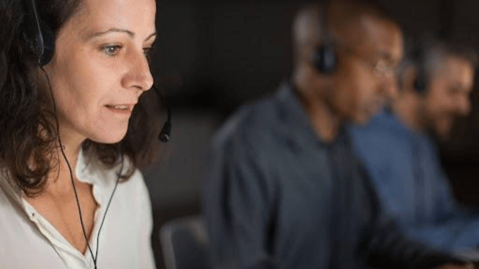 Esta imagem retrata uma equipe de suporte ou atendimento em um ambiente corporativo dinâmico.