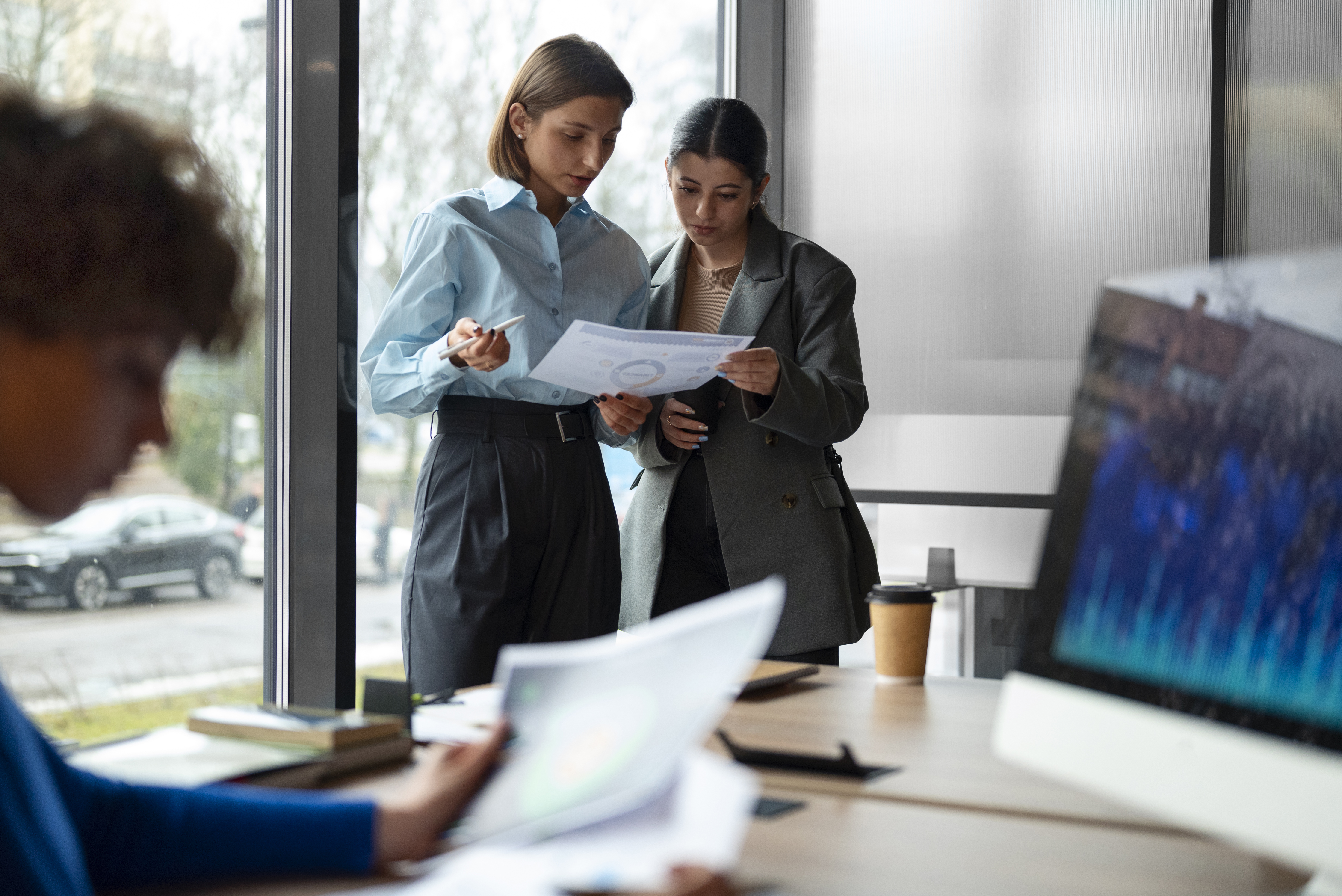 A imagem retrata um ambiente corporativo moderno, com foco em análise e tomada de decisão.